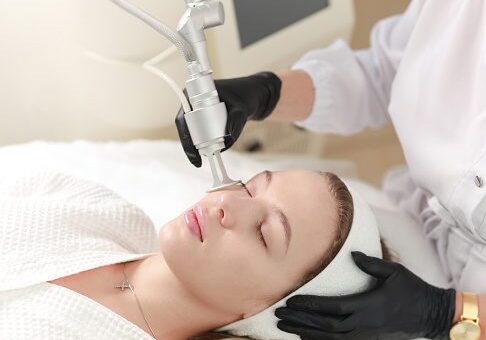 Woman receiving a facial laser treatment in a clinic.